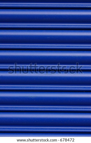 Glossy blue roller security shutters on a shop in North Wales.
