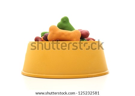 An isolated dog bowl with dog biscuits on a white background.