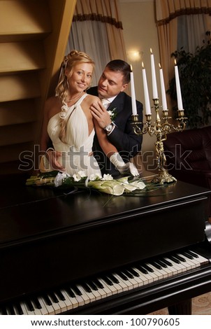 Wedding couple with candles at the piano.
