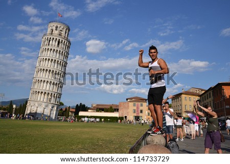 PISA, ITALY - JULY 16: Tourist posing in front of the Leaning tower of Pisa on July 16 2012 in Pisa, Italy. The Leaning Tower is one of the landmarks available in new 45Ã?Â° imagery in Google Maps.