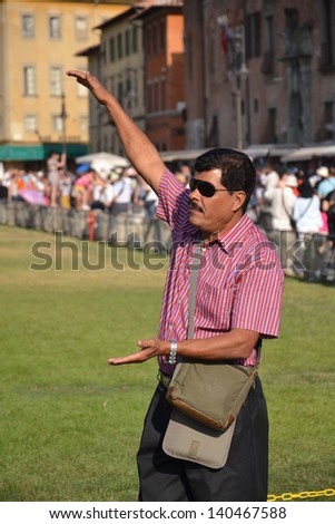 PISA, ITALY - JULY 16: Tourist posing in front of the Leaning tower of Pisa on July 16 2012 in Pisa, Italy.