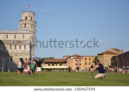 PISA, ITALY - JULY 16: Tourists posing in front of the Leaning tower of Pisa on July 16 2012 in Pisa, Italy.