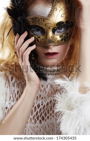 Beautiful young woman in gold mysterious venetian mask. Fashion photo