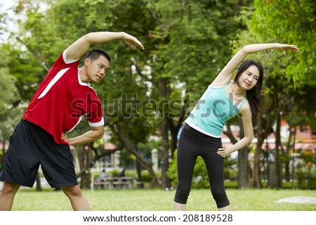 Happy couple training in the park - Young man and woman during summer workout and sport activity