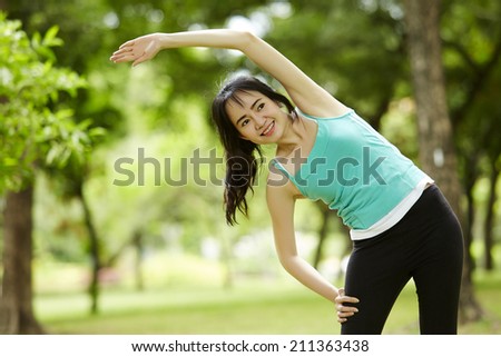 Stretching woman in outdoor exercise smiling happy doing yoga stretches after running-Beautiful happy smiling sport fitness
