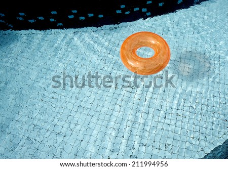 Orange pool float, pool ring in cool blue refreshing swimming pool