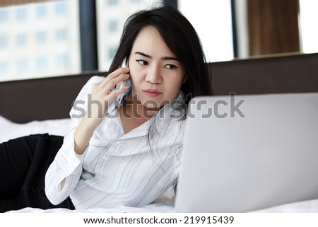 Businesswoman working on her laptop in the bed