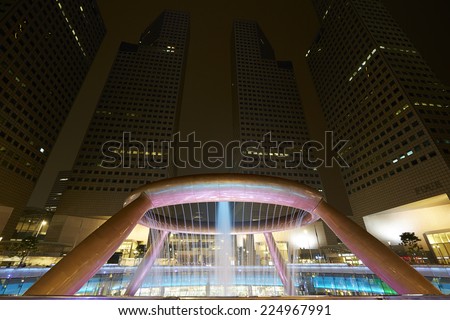 SINGAPORE-OCT 18: Fountain of Wealth with Suntec Towers at dusk on OCT 18,2014 in Singapore. Fountain of wealth is the biggest fountain in Singapore located Suntec Towers, SINGAPORE.