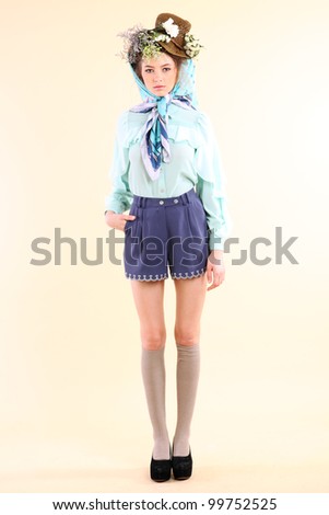 Fashion model in spring light blue and purple clothes on beige background.