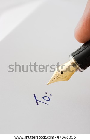 A fountain pen in position to write on paper next to already written text, \