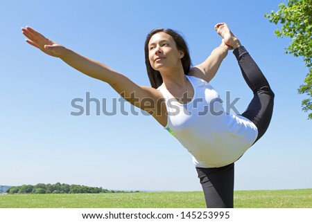 Portrait of a Young Woman performing Yoga outdoors in the country side