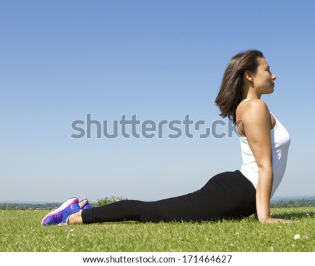 Portrait of a Young woman doing a cobra yoga pose