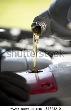 Fresh oil being poured during an oil change to a car
