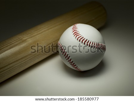 Sports concept of a new baseball and wooden bat with the light mainly focused on the ball
