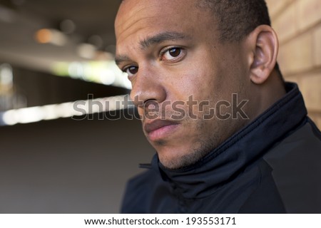 Portrait of a sad, depressed man unhappy with his prospects sitting in a tunnel looking out to the distance. Social issues concept