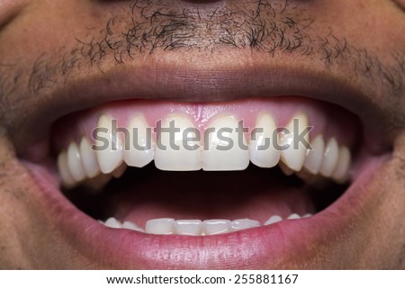 Close up macro shot of a male mouth laughing and showing his straight teeth