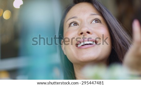 Attractive young woman with a cheerful face as she talks to an unseen friend