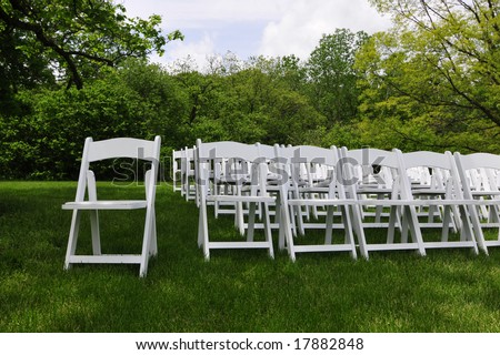 stock photo Rows of white folding chairs from an outdoor wedding
