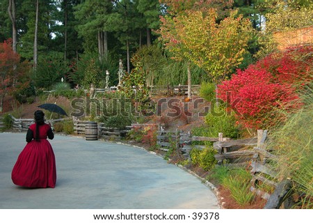 A woman in full Victorian costume enjoys fall at Stone Mountain Park in Georgia