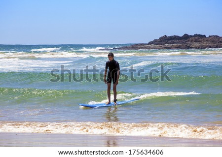 young teen boy learning how to surf