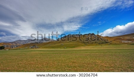 Farm in a New Zealand landscape against blue sky