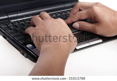 Female hands typing on a keyboard of a mini laptop