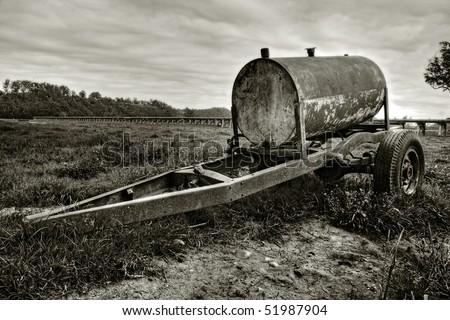 Rusty oil drum wagon on grass