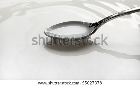 spoon full of milk over a bowl