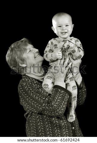 grandmother holding young toddler against black background