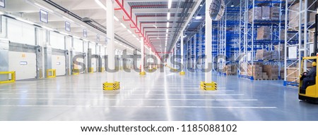 Huge distribution warehouse with high shelves and loading gates.