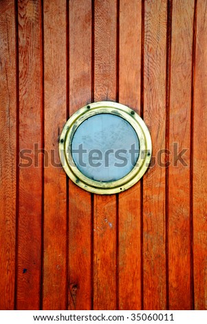 circular window on a timber door of a boat