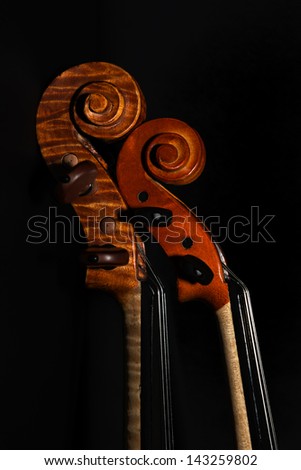 Full size and half size violin scroll and pegbox against black back ground