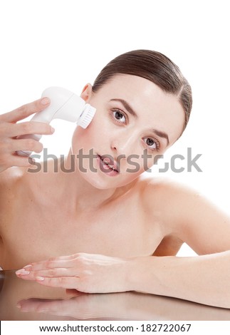 Woman with brush for deep cleansing facial. Skin care concept. High technology beauty.