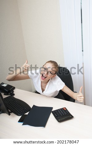Business woman celebrating victory at the laptop computer with thump up.
