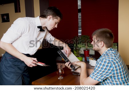 Man makes an order  to the waiter at a restaurant.