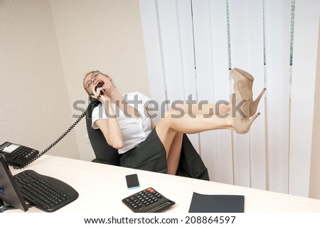 laughing business woman on landline phone call, listening to conversation.