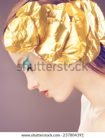 Profile of beautiful sensual fashion girl with golden decoration on the head, blue makeup.