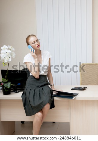 Busy office girl talking on mobile phone.