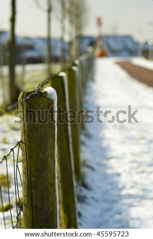 a fence in the snow on a sunny winter-day