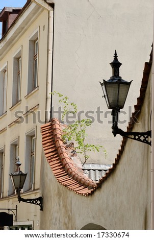 Inverted arch covered with tiles. Two lamps are to the sides of it. The picture is taken in Tallinn.