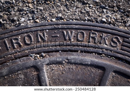 Close up of a metal manhole cover with the words Iron Works.
