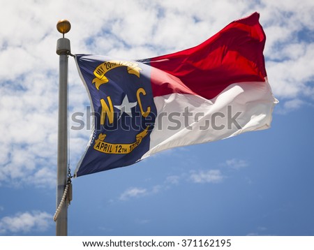 Close up view of the North Carolina flag waving in the wind in the afternoon.