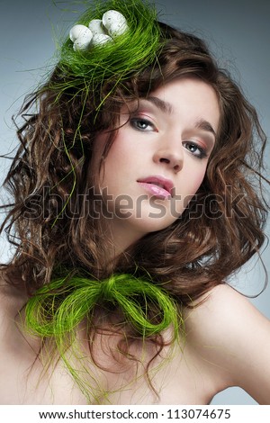 Easter picture of young woman with nest and eggs on her head