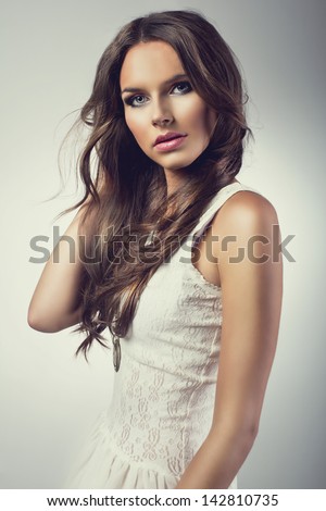 Portrait of beautiful brunette woman wearing white dress
