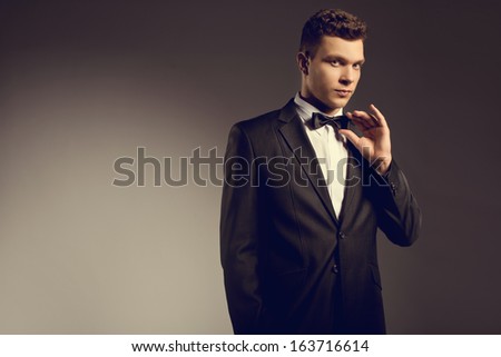 Elegant young handsome man wearing suit at studio fashion portrait