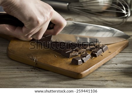 Chopping a Bar of Chocolate while Making Chocolate Pudding or Baking