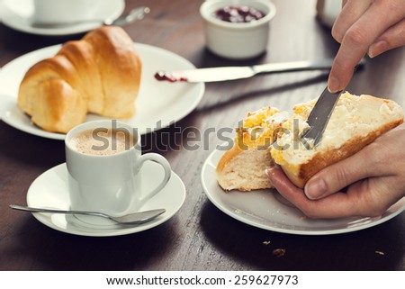 Spreading Butter on a PÃ£o de Deus Roll in a Portuguese Cafe