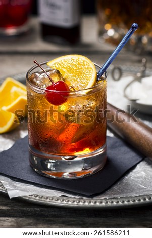 Old Fashioned Cocktail in Vintage Inspired Bar with Liquor Bottles and Ingredients