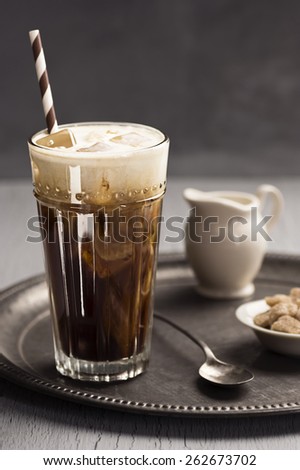 Cream on Top Swirls Into Glass of Iced Coffee with Straw