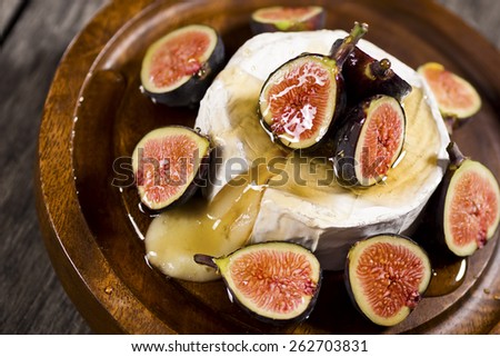 Warm Brie Cheese Cut Open and Topped With Sliced Figs and Honey